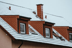 Home roof of a house with many dormers covered by snow in winter